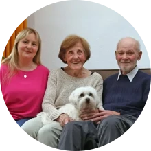 Älteres Ehepaar mit Betreuungskraft und Hund zu Hause